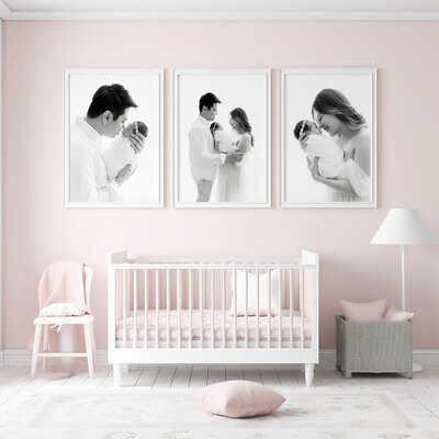 Three black and white images hang in frames on a wall above a crib