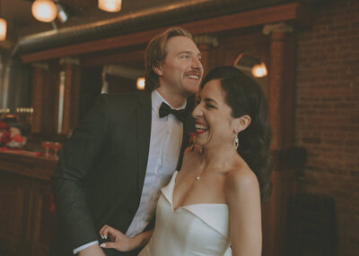 bride and groom at bar laughing