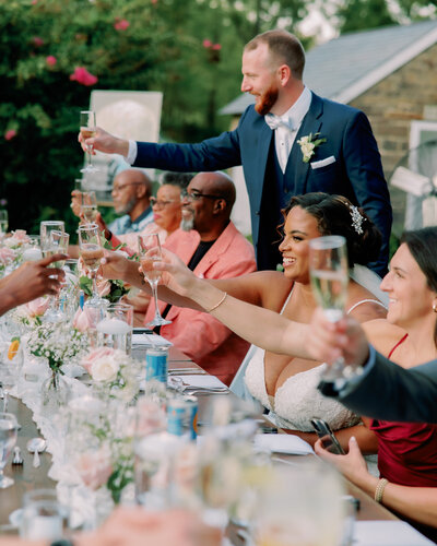 Wedding guests raise their glasses in a toast at Woolverton Inn.