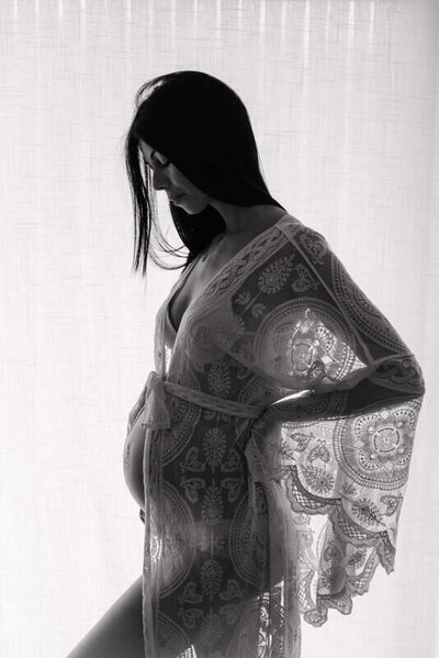 Vrouw in kanten kimono voor raam  intiem moment van me-time en zachtheid






