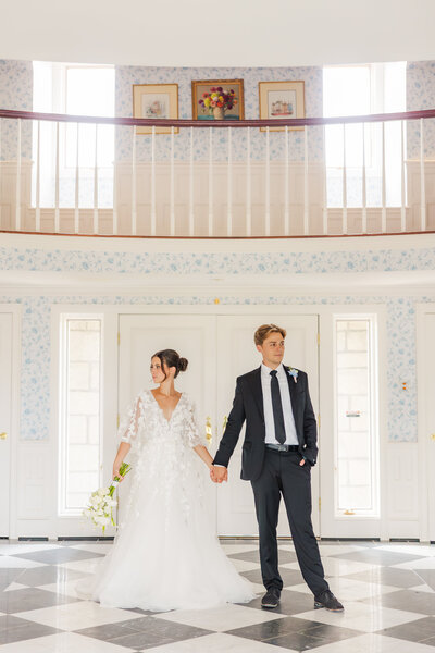 Bride and groom holding hands looking in opposite directions on their wedding at the Greystone Castle in Boulder, Colorado.