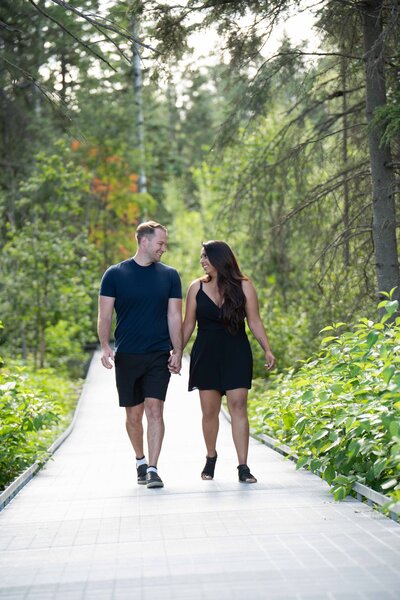 Engagement session at the AgaKhan Gardens - couple walking on pathway holding hands and laughing