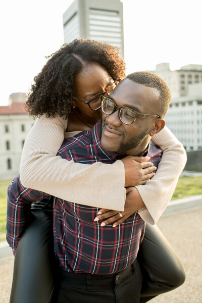 A lady jumps on her boyfriends back at the Virginia state capital during their engagement photo session.
