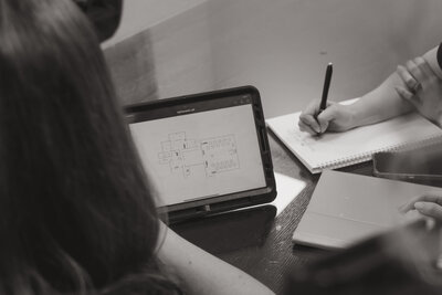 women working around a macbook