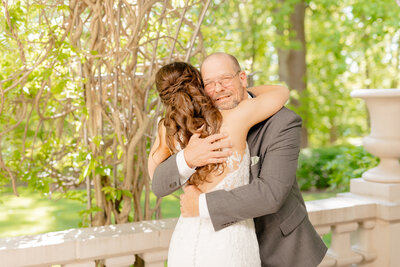 A bride shares a first look with Liriodendron Mansion Wedding Photographer on the back porch of the Liriodendron Mansion.