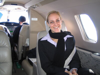 Salome Schillack  sitting and smiling on a private jet flight from London to France