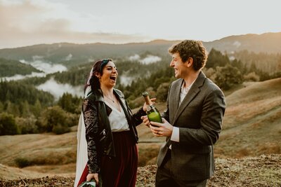 Same-sex couple laughing with joy during their Big Sur adventure elopement