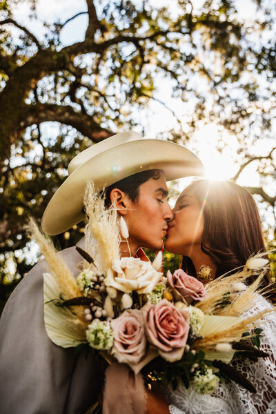 a couple kissing with a sunflare behind them - orlando wedding and elopement photographer - shannon lee photography