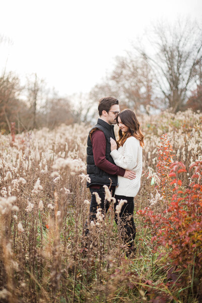 engaged couple standing in a field in Knoxville