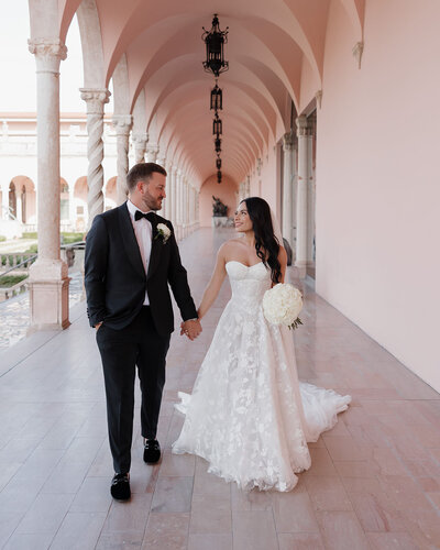 bride and groom walk through the Ringling art museum