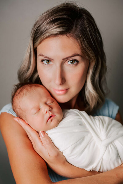 Mom holding baby wrapped in  white