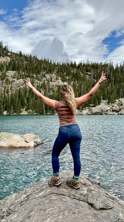 Shannon Michele throwing up peace signs looking out over Bear Lake in Colorado