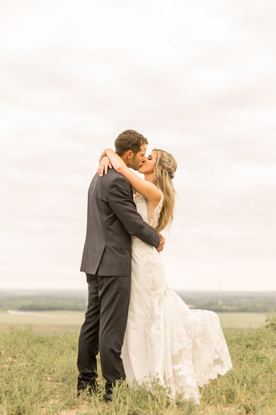 Bride and groom kiss during wedding photos on their special day