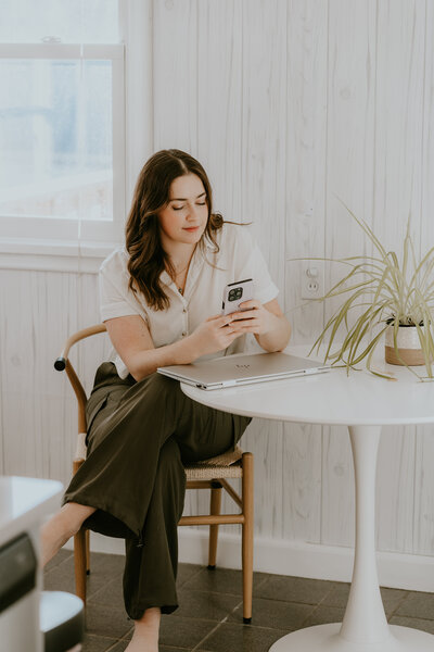 Rachel Haselwander, OBM and owner of Agera Business Services holding her laptop smiling