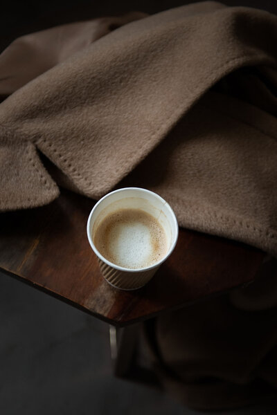 coffee cup aesthetically placed on winter coat for social media brand shoot