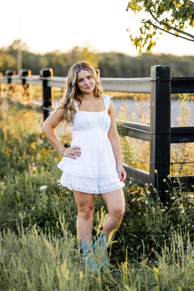 Teen girl highlighting her blue cowboy boots during a fun and personal senior portrait shoot
