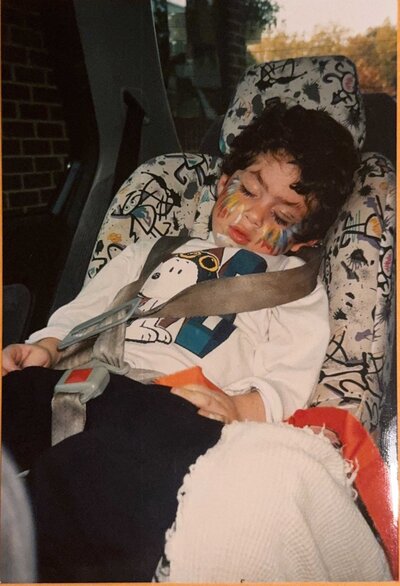 A young boy asleep in a carseat