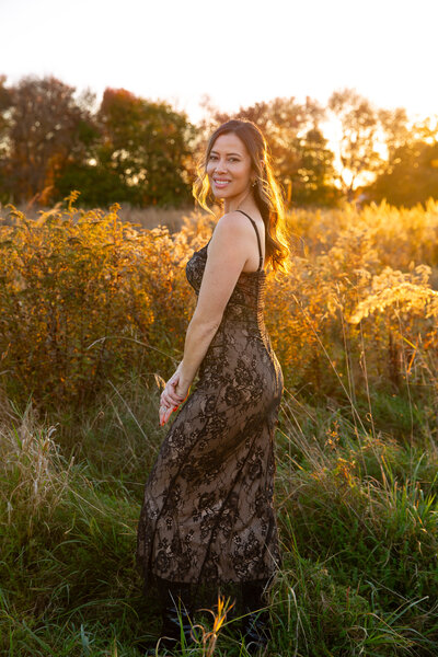 Fairfield photographer posing for headshot with hand under chin and holding camera with other hand