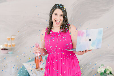 Isabel Kateman in a pink dress with confetti holding a laptop