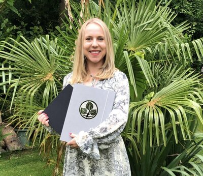 Picture of Owner of Selin Marketing holding her diploma