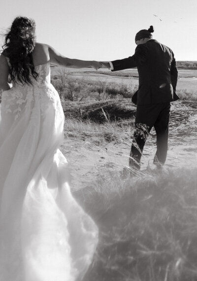 Couple holding hands at their wedding at the Avenue Room in Saskatoon.
