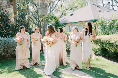 bride and bridesmaids walking in the spring sunlight at hummingbird house, austin garden wedding venue