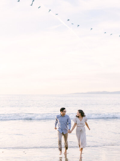Beach engagement couple holding hands