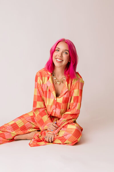 Bridget Blood is a professional photographer in OKC posed with disco balls and a fun floral blazer