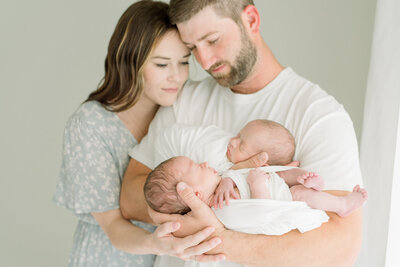 Light and airy Redding California portrait studio photographed a mother and father holding their newborn twin boys.