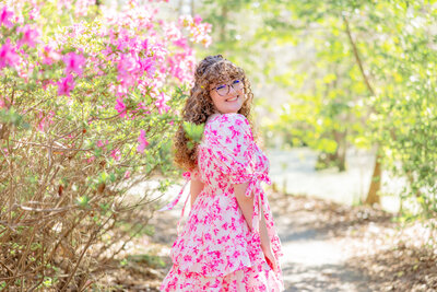 high school senior with blooming pink flowers at Cypress Gardens