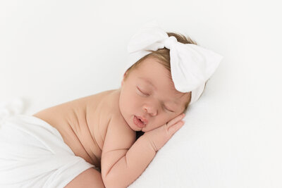 Sweet newborn girl on beanbag in studio