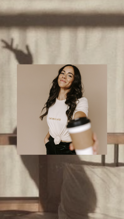 A brunette woman in a white tee shirt holding out her coffee cup to the camera during a brand content day for social media efforts. 