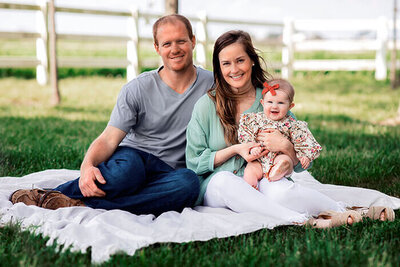 family-sits-on-blanket-in-field