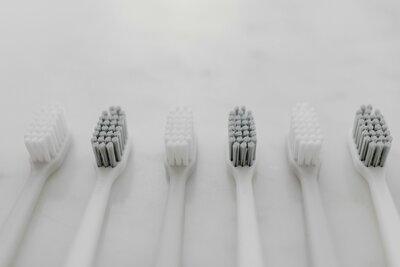 Detail bílých a šedých zubních kartáčků – symbol péče a hygieny