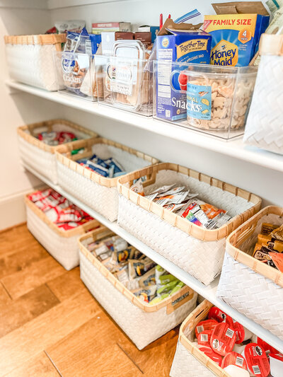 Pantry products grouped with like items and decanted into clear containers.