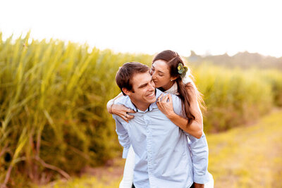 Woman piggy back riding on her man while kissing his head