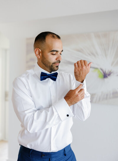 Rafael getting ready in a white tuxedo at La Siesta Marina Resort, captured by Claudia Amalia Wedding Photography.