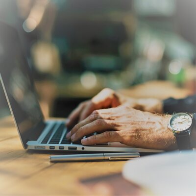 man typing on laptop