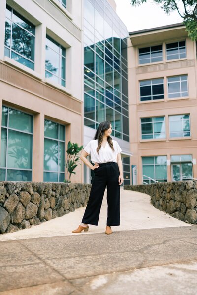 Woman posing in front of an office building wearing business professional clothing