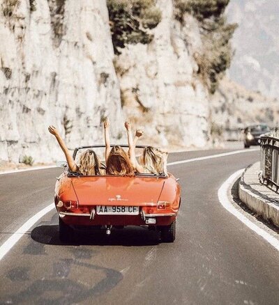 Inspirational scene of a convertible driving on a coastal highway at sunset, radiating freedom