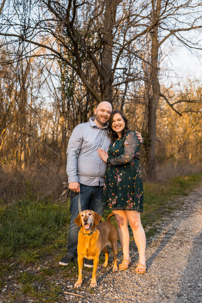 Couple smiles with their dog while going for a walk at Eagle Creek Park
