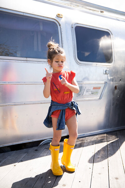 Greer Rivera Photographer Editorial Features Bay Area Photographer Girl making a funny face and shaking finger in rain boots