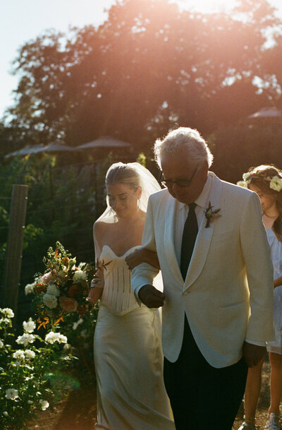 bride walking down aisle with her father