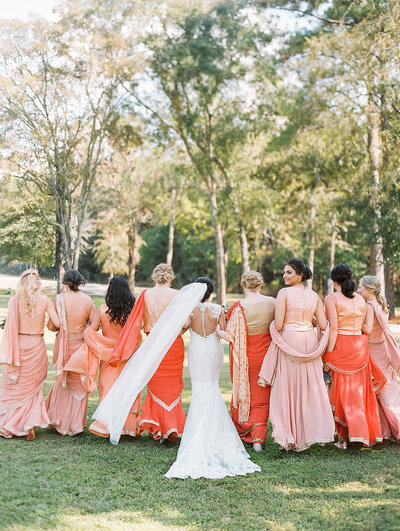Back view of bride and bridesmaids dressed in colorful Indian wedding attire