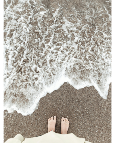 Feet near the water on a beach