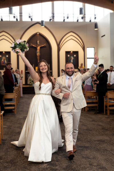 Newlywed couple cheering and celebrating right after saying ‘I do’ during their Utah wedding, captured by Lamblight Photography