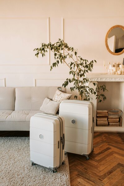 Minimalist travel scene showing two suitcases ready in a cozy living room, capturing the early stages of traveling abroad with young kids.