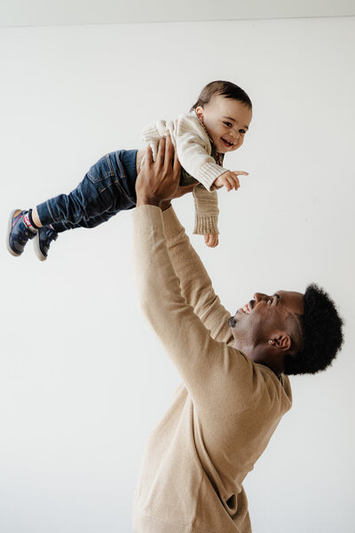 man holding up son