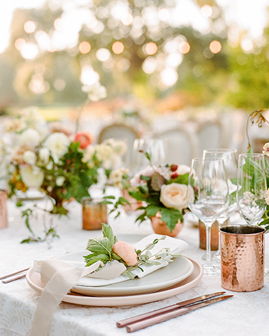Wedding dinner tablescape using peach florals and copper accents