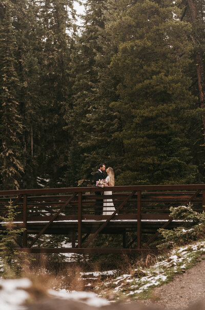 A couple poses on a bridge during their Montana elopement.